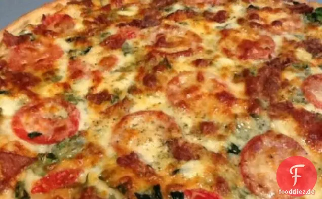 Pizza mit Speck, Tomaten und Spinat
