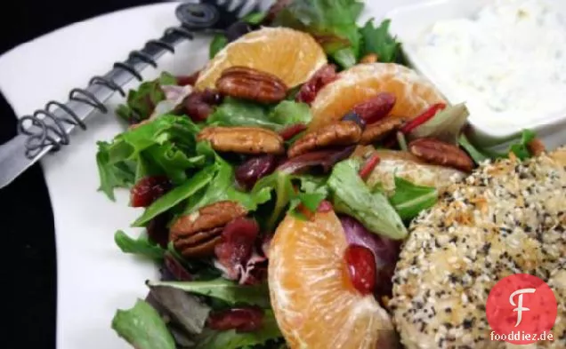 Gemischter grüner Salat mit Orangen, getrockneten Preiselbeeren und Pekannüssen