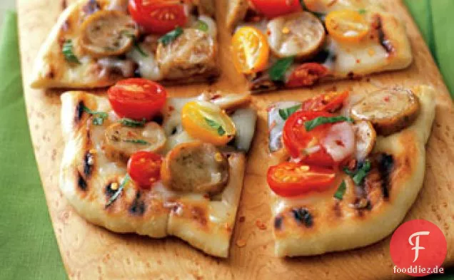 Pizza mit Wurst, Tomaten und basilikum