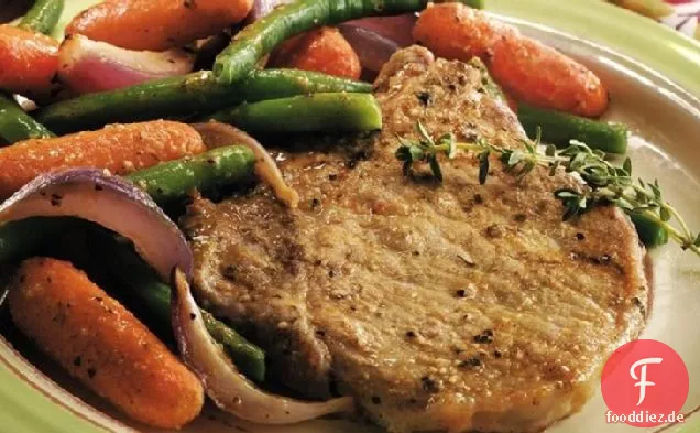Ofengebratene Schweinekoteletts und Gemüse