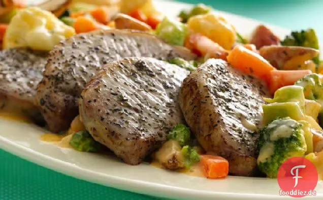 Gebratene Schweinekoteletts mit käsigem Gemüse