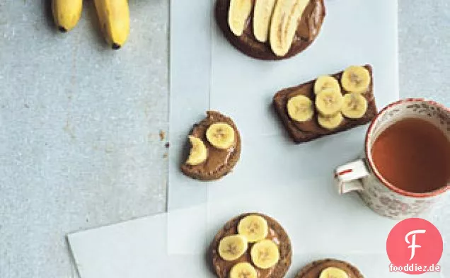 Mandelbutter und Finger Bananen auf Fruchtbrot