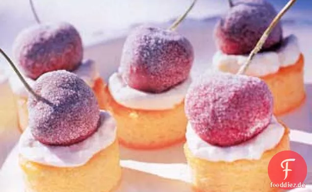 Miniatur-Mandelkuchen mit gezuckerten Kirschen und Kirschcreme