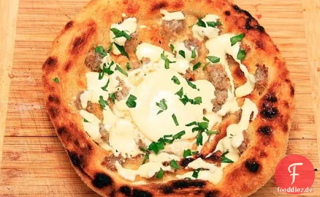 Frittierte Frühstückspizza mit Wurst, Eiern, Parmesan und Hollandaise