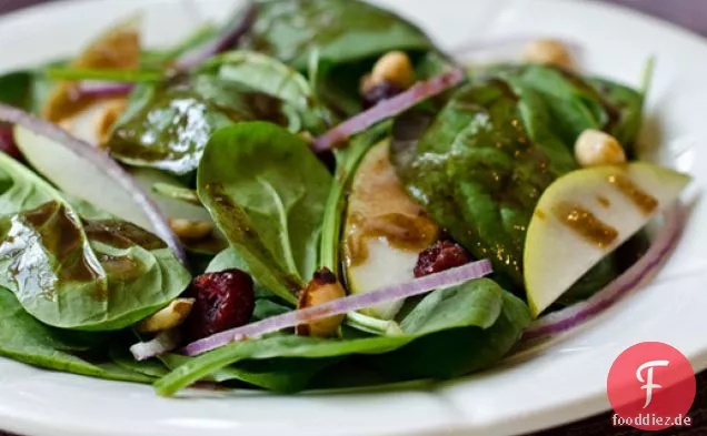 Baby-Spinatsalat mit Birnen, roten Zwiebeln, Preiselbeeren und gerösteten Haselnüssen