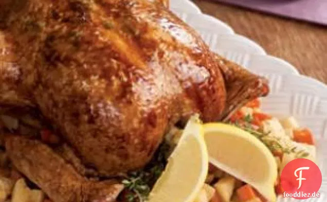 Ganzes geröstetes Zitronen-Kräuter-Huhn auf einem Gemüsebett