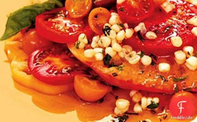 Geschnittene Tomaten mit Mais und Basilikum