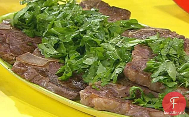 T-Bone Steaks mit gehackter grüner Garni, gebratene Tomaten mit Käse, Oliven und Kräutern