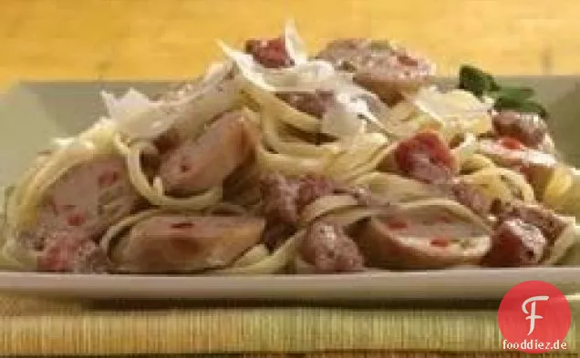 Gegrillte süße italienische Hühnerwurst mit Tomatenrahmsauce über Linguine