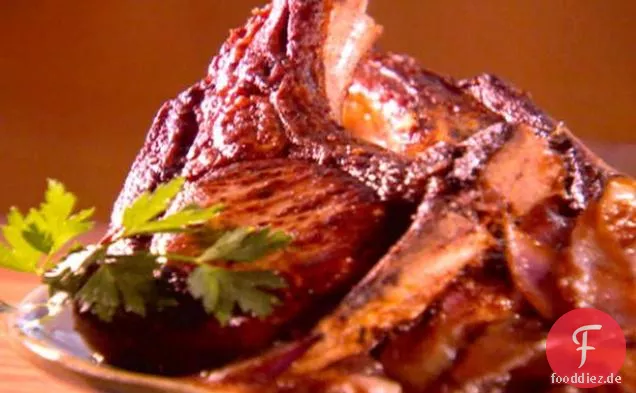 Dick geschnittene senfmarinierte Schweinekoteletts mit karamellisierten roten Zwiebeln