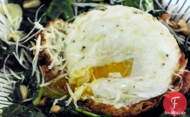 Knoblauchgrün mit Pinienkernen und einem Ei