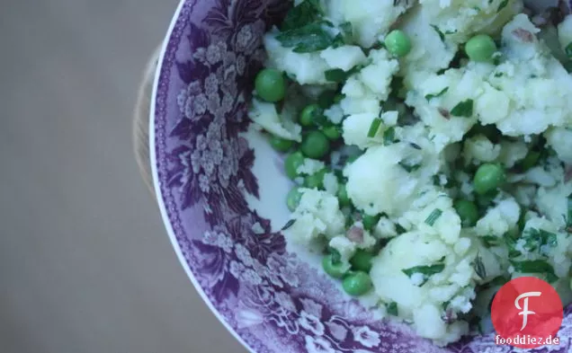 Zertrümmerte neue Kartoffeln mit frischen Erbsen, Petersilie und Schnittlauch