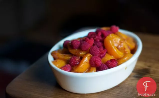 Geschmolzene Aprikosen mit frischen Himbeeren