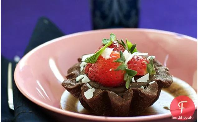 Dunkle Schokoladentörtchen mit Erdbeeren und Kokosraspeln