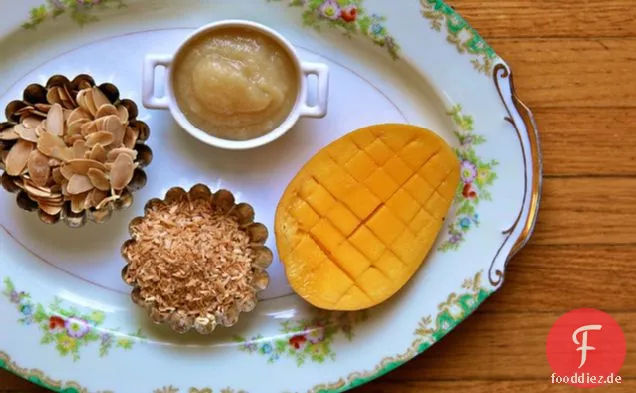 Frühstück Quinoa mit gerösteter Kokosnuss, Mandeln und frischer Mango