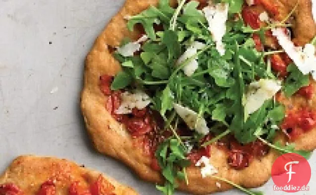 Individuelle Pizzen mit Pecorino, Rucola und Tomaten
