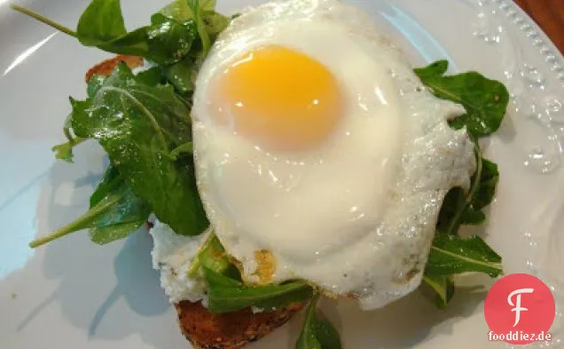 Sandwiches mit offenem Gesicht mit Ricotta, Rucola und Spiegelei
