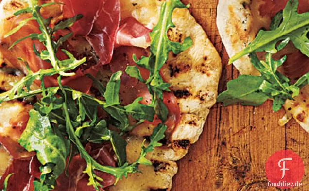 Gegrillte Pizza mit Schinken, Rucola und Zitrone