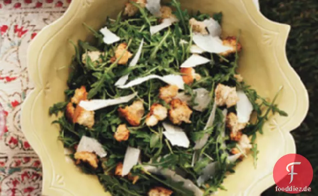 Wilder Rucola-Salat mit Knoblauchcroutons, rasiertem Parmesan und Zitrone