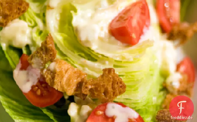 Verdrehter Eisbergsalatsalat mit warmem Gorgonzola-Dressing